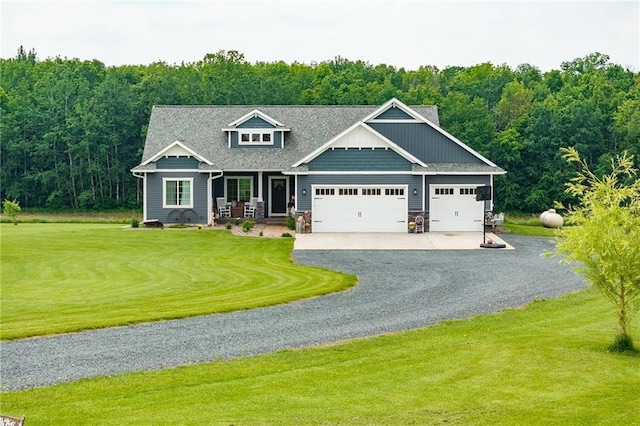 4801 358th St, Stanley, WI 54768 - view of front of home featuring gravel driveway, a front lawn, a garage, covered porch, and a forest view