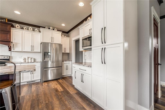4801 358th St, Stanley, WI 54768 - kitchen featuring appliances with stainless steel finishes, dark wood finished floors, decorative backsplash, light stone counters, and a textured ceiling