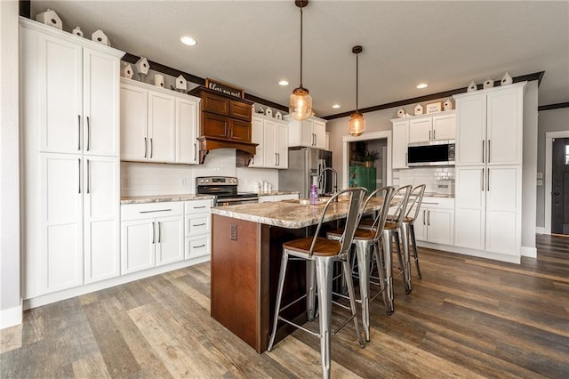 4801 358th St, Stanley, WI 54768 - kitchen with appliances with stainless steel finishes, backsplash, dark wood-style flooring, a breakfast bar, and white cabinetry