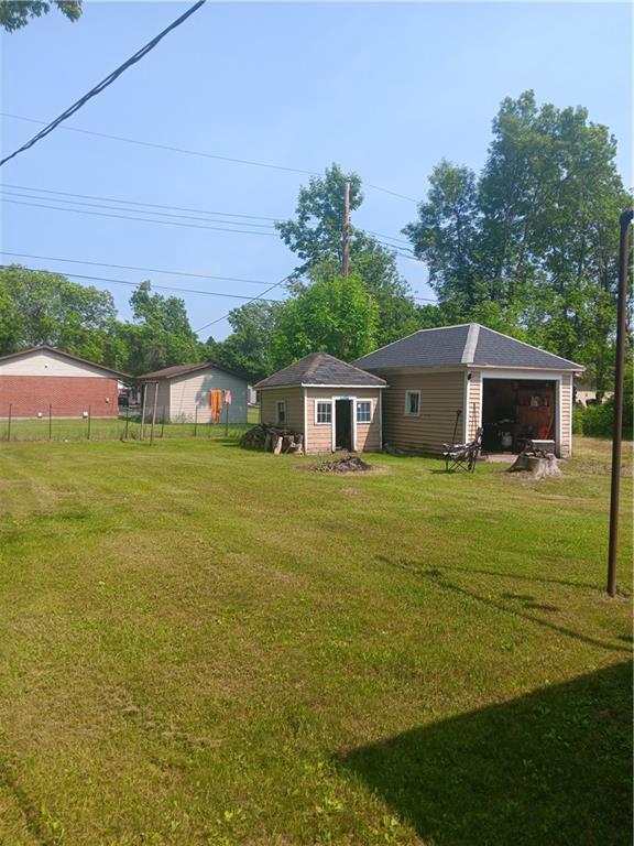 905 E 1st St, Ladysmith, WI 54848 - view of green lawn with an outdoor structure and a detached garage