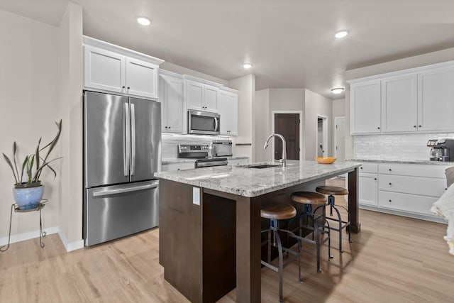 N9225 Constellation Dr, Appleton, WI 54915 - kitchen featuring stainless steel appliances, decorative backsplash, white cabinetry, light wood-style floors, and recessed lighting