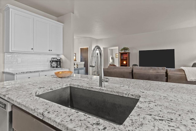 N9225 Constellation Dr, Appleton, WI 54915 - kitchen featuring open floor plan, white cabinets, light stone counters, tasteful backsplash, and dishwasher