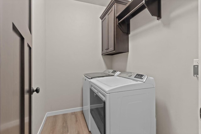N9225 Constellation Dr, Appleton, WI 54915 - washroom featuring separate washer and dryer, cabinet space, and light wood-type flooring