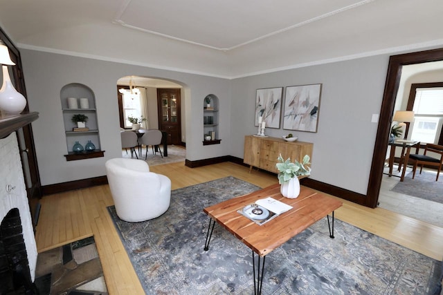 1522 S Sunny Slope Rd, New Berlin, WI 53151 - living area featuring arched walkways, wood-type flooring, built in shelves, and a tray ceiling