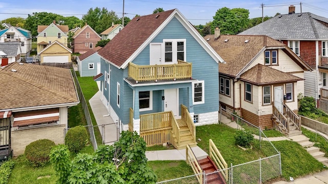3425 N 20th St, Milwaukee, WI 53206 - view of front of house featuring a balcony, a fenced backyard, a residential view, and a gate
