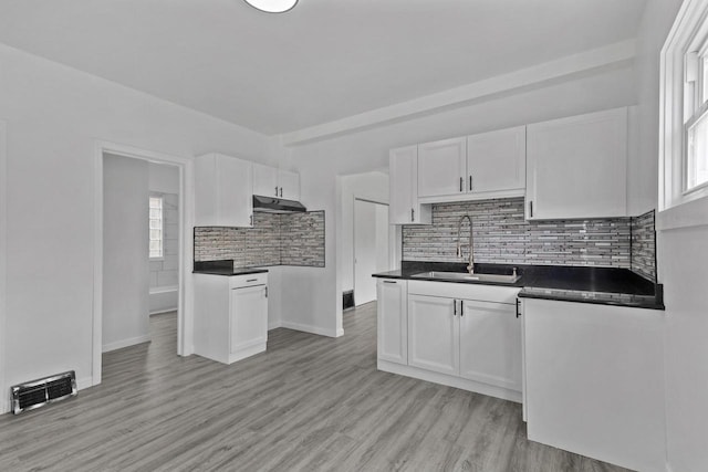 3425 N 20th St, Milwaukee, WI 53206 - kitchen with white cabinets, tasteful backsplash, dark countertops, and light wood-type flooring