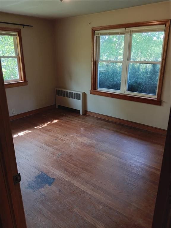 102 E College Ave, Ladysmith, WI 54848 - empty room featuring radiator and wood finished floors