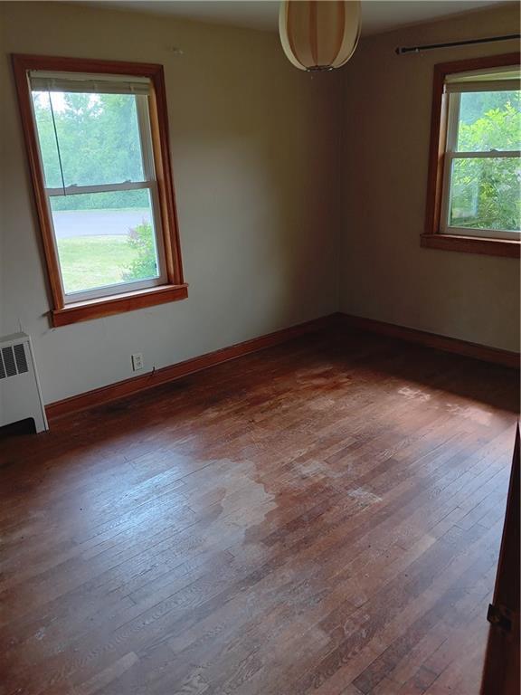 102 E College Ave, Ladysmith, WI 54848 - spare room featuring hardwood / wood-style flooring and radiator heating unit