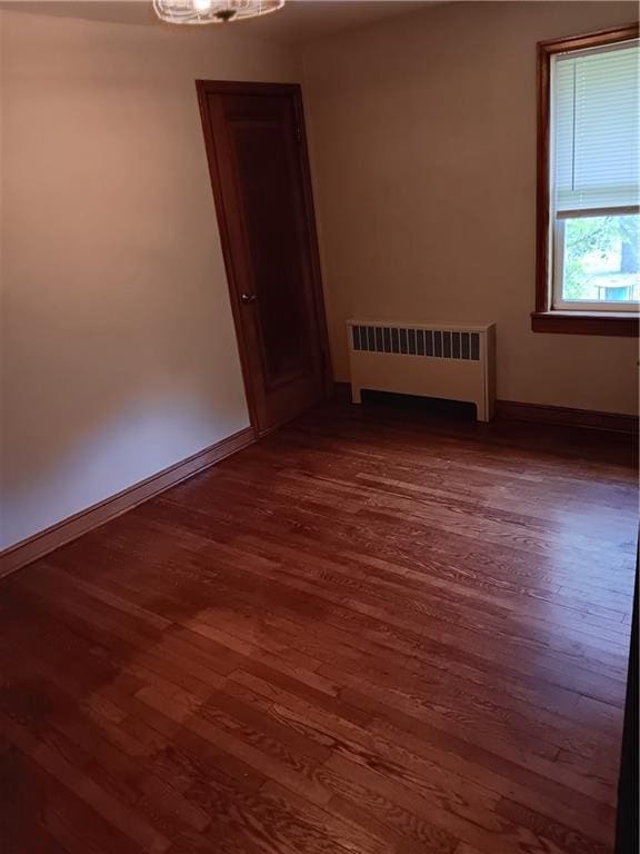 102 E College Ave, Ladysmith, WI 54848 - spare room featuring radiator heating unit and dark wood-style flooring