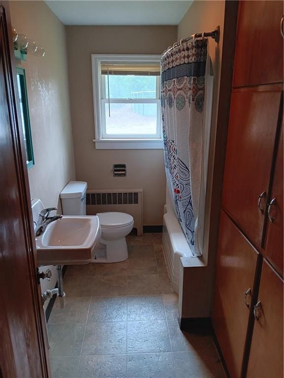 102 E College Ave, Ladysmith, WI 54848 - full bath with radiator heating unit and shower / bath combo with shower curtain