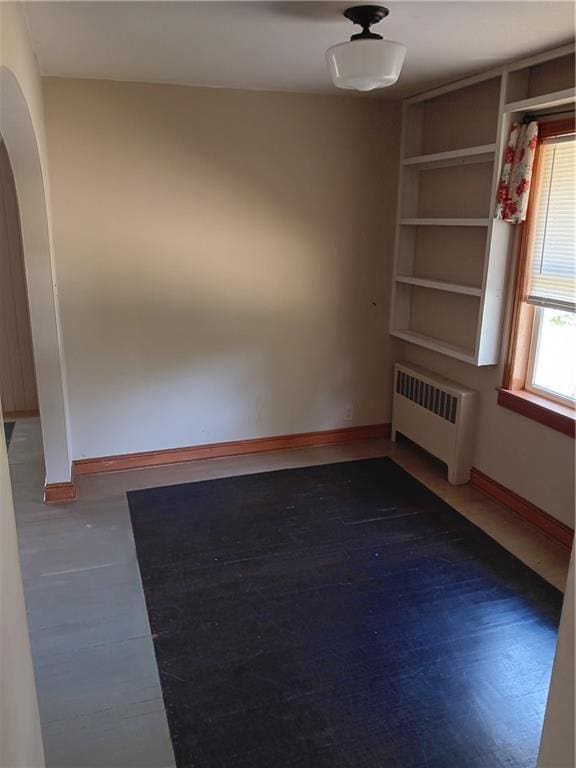 102 E College Ave, Ladysmith, WI 54848 - unfurnished room featuring radiator and arched walkways