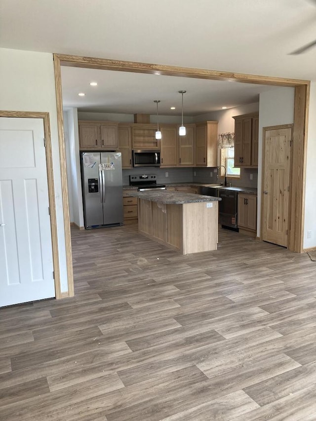 501 View St, Tomah, WI 54660 - kitchen with appliances with stainless steel finishes, recessed lighting, light wood-type flooring, a center island, and dark countertops
