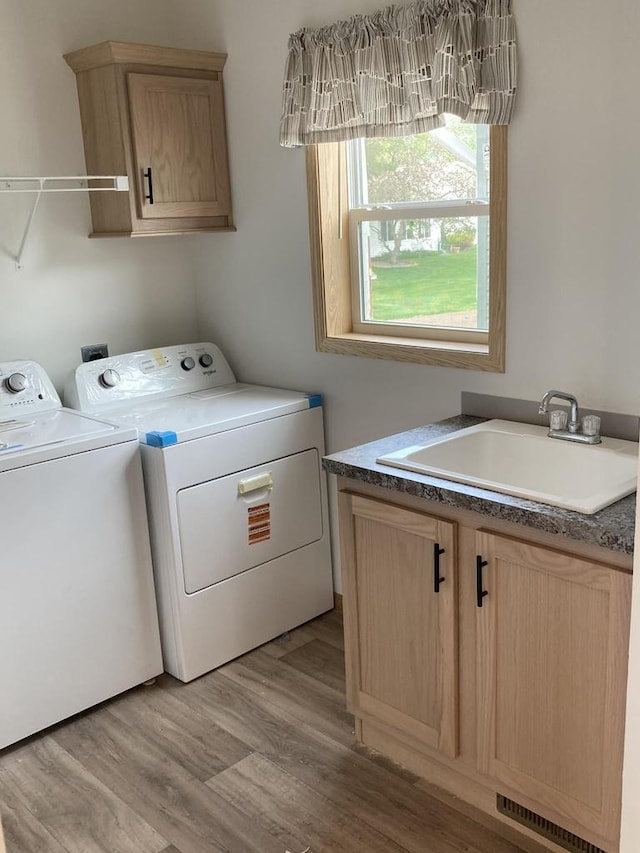 501 View St, Tomah, WI 54660 - laundry area featuring washer and clothes dryer, cabinet space, and light wood finished floors