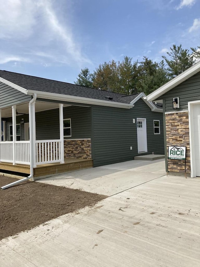 501 View St, Tomah, WI 54660 - view of front of home with stone siding, a porch, and roof with shingles