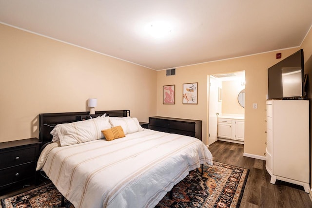 1906 E Shorewood Blvd Unit 250, Shorewood, WI 53211 - bedroom featuring dark wood-style flooring, connected bathroom, and ornamental molding