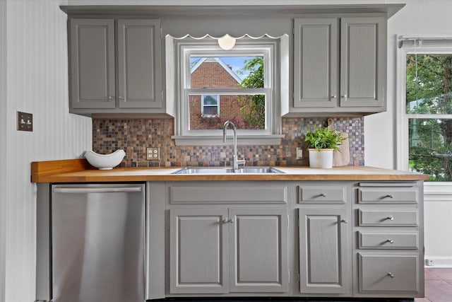10836 W Fiebrantz Ave, Wauwatosa, WI 53222 - kitchen with stainless steel dishwasher, gray cabinetry, butcher block counters, backsplash, and plenty of natural light