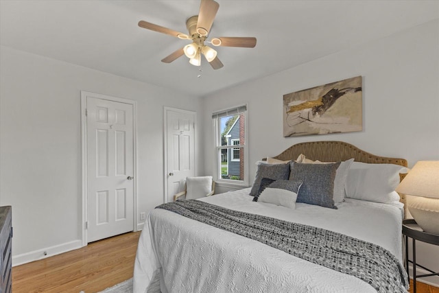 10836 W Fiebrantz Ave, Wauwatosa, WI 53222 - bedroom featuring light wood-type flooring, multiple closets, and ceiling fan