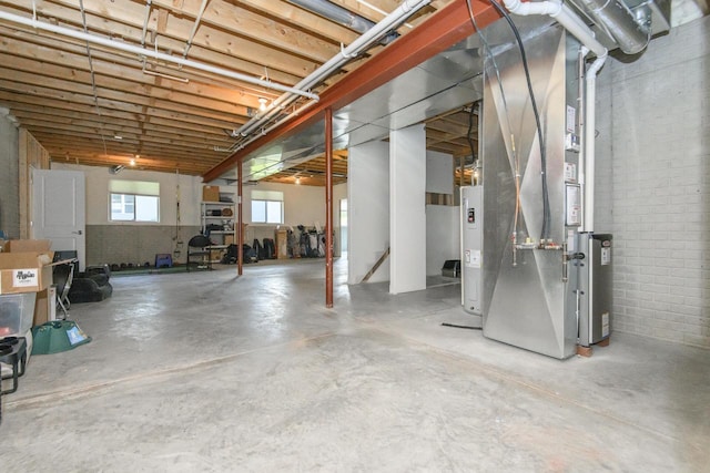 12907 78th Pl, Bristol, WI 53104 - below grade area featuring electric water heater, heating unit, and brick wall