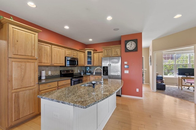 9414 Harvest Moon Ln, Verona, WI 53593 - kitchen with stainless steel appliances, an island with sink, glass insert cabinets, dark stone countertops, and backsplash