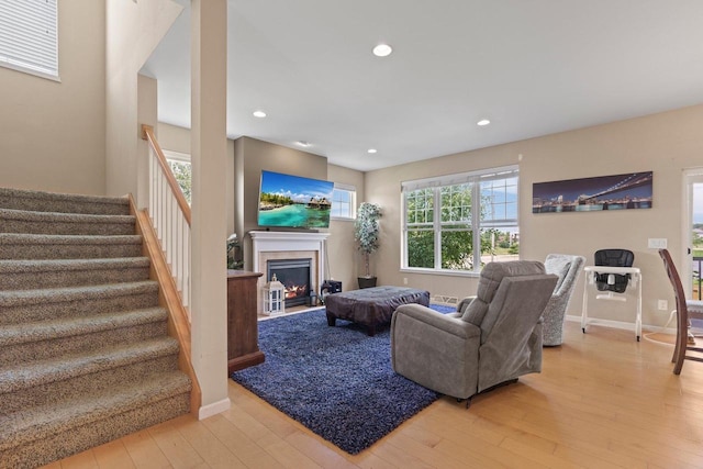 9414 Harvest Moon Ln, Verona, WI 53593 - living room with a lit fireplace, light wood finished floors, stairway, recessed lighting, and plenty of natural light
