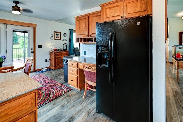 830 Violet Ln, Oregon, WI 53575 - kitchen featuring black fridge, ceiling fan, wood finished floors, brown cabinetry, and tasteful backsplash
