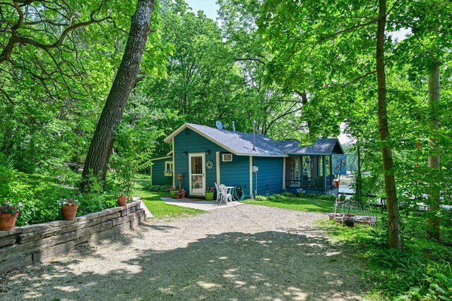 9034 N County Road F, Edgerton, WI 53534 - rear view of property featuring a wall unit AC and roof with shingles