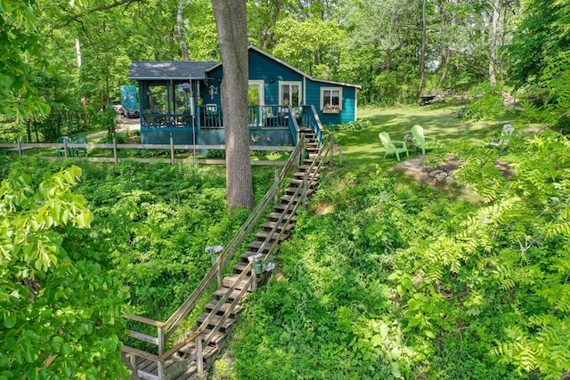 9034 N County Road F, Edgerton, WI 53534 - view of yard featuring stairway, a sunroom, a deck, and view of scattered trees