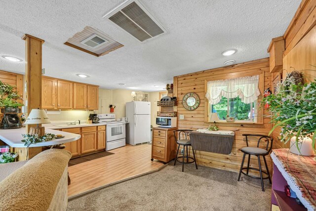 9034 N County Road F, Edgerton, WI 53534 - kitchen featuring white appliances, wooden walls, light countertops, a textured ceiling, and light colored carpet