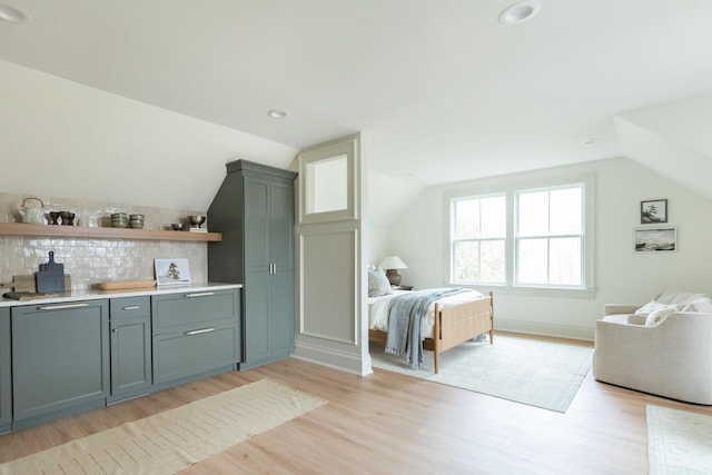 545 Wisconsin Ave, Delafield, WI 53018 - bedroom with light wood-type flooring, lofted ceiling, and bar area