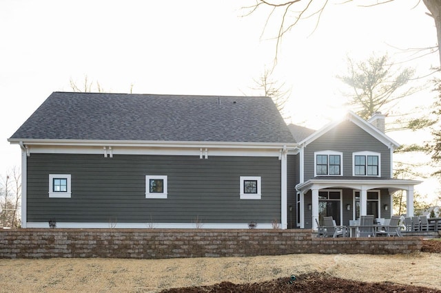 545 Wisconsin Ave, Delafield, WI 53018 - rear view of house with a porch, a chimney, and roof with shingles