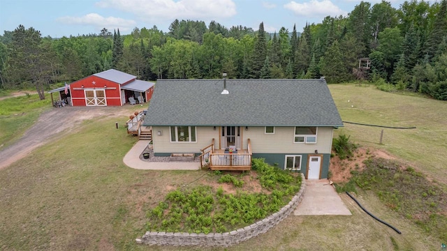 7684 E Moose Lake Rd, Solon Springs, WI 54873 - rear view of house featuring a yard, a wooden deck, an outdoor structure, a view of trees, and a pole building