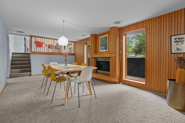24 Hazelwood Dr, Stevens Point, WI 54481 - carpeted dining room featuring healthy amount of natural light, stairway, a glass covered fireplace, and wood walls
