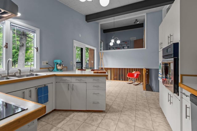 24 Hazelwood Dr, Stevens Point, WI 54481 - kitchen with stainless steel oven, beamed ceiling, stovetop, light countertops, and light tile patterned floors