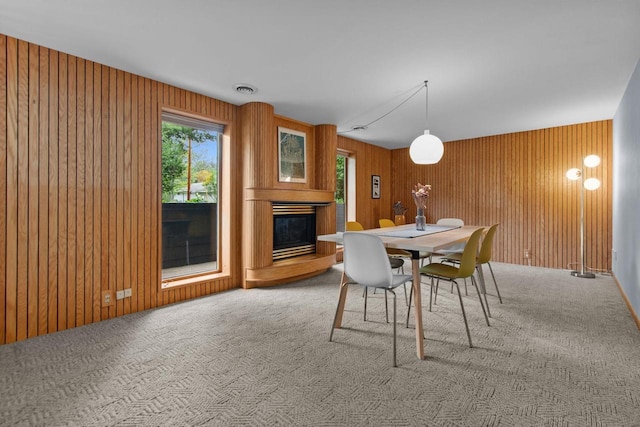 24 Hazelwood Dr, Stevens Point, WI 54481 - dining space featuring a glass covered fireplace, carpet flooring, and wooden walls