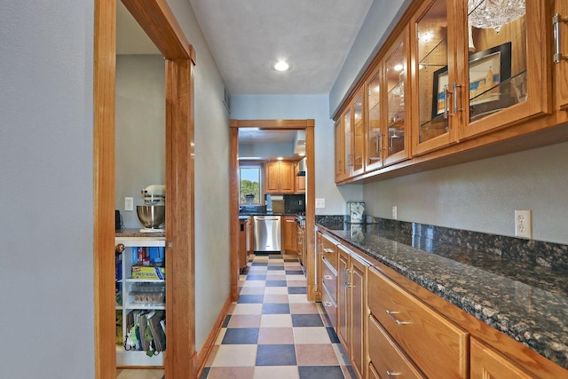 1434 43rd Ave, Kenosha, WI 53144 - kitchen featuring dishwasher, brown cabinetry, light floors, dark stone counters, and glass insert cabinets
