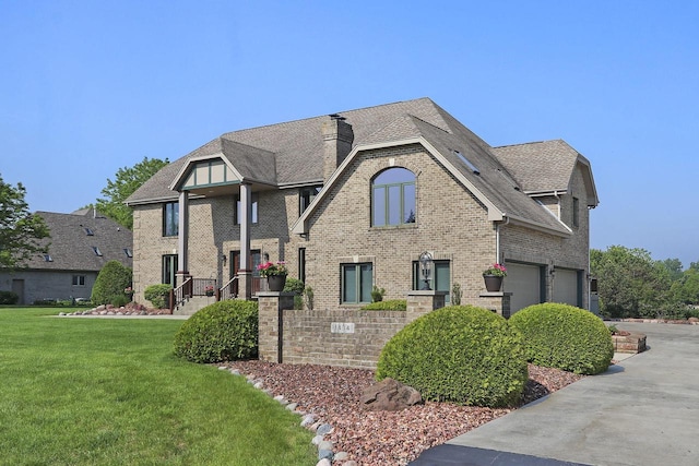 1434 43rd Ave, Kenosha, WI 53144 - view of front of house with brick siding, a front yard, a chimney, a garage, and driveway