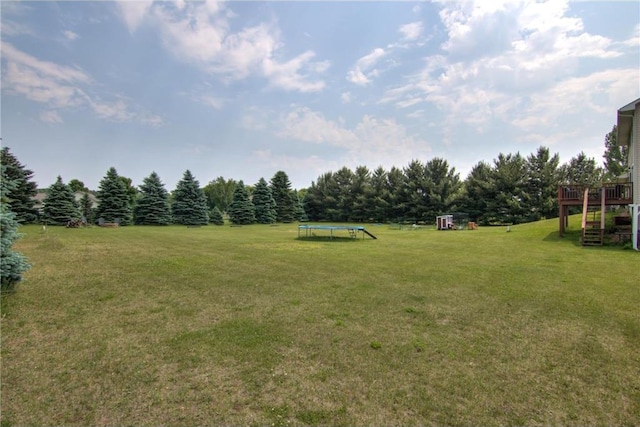 2207 127th St, New Richmond, WI 54017 - view of grassy yard with a trampoline, a deck, and stairs