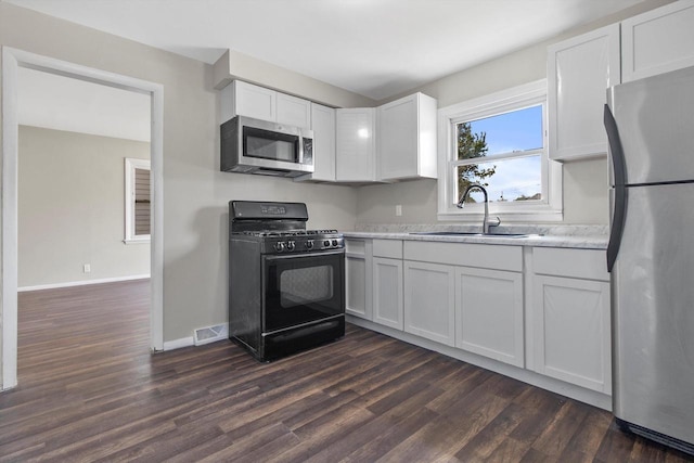 1933 Jay Eye See Ave, Racine, WI 53403 - kitchen featuring stainless steel appliances, dark wood-style floors, and white cabinetry
