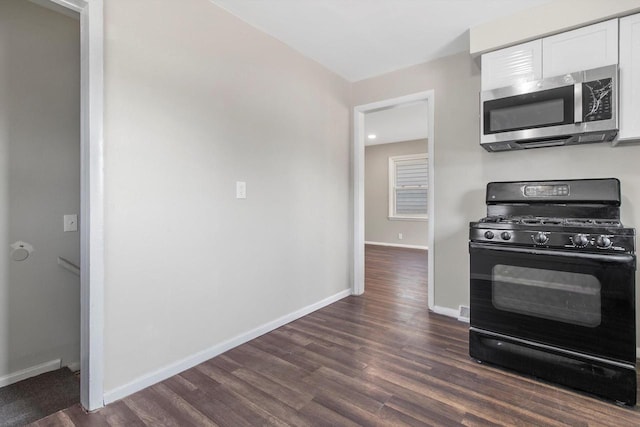 1933 Jay Eye See Ave, Racine, WI 53403 - kitchen with stainless steel microwave, black gas range oven, white cabinetry, and dark wood finished floors