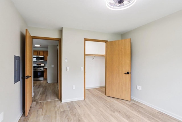 33A Grand Canyon Dr Unit 110, Baraboo, WI 53913 - unfurnished bedroom featuring light wood finished floors, electric panel, a closet, and a walk in closet