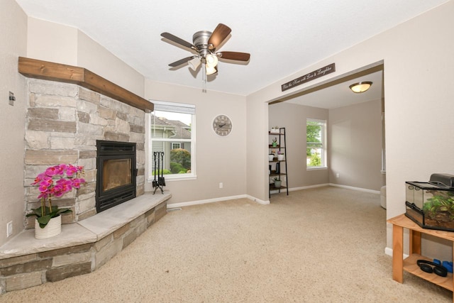 1557 Serena Ln, Burlington, WI 53105 - living area featuring a stone fireplace, a ceiling fan, and carpet