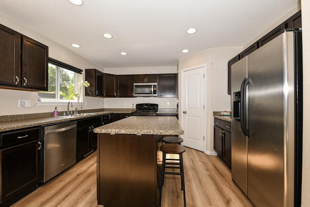 1557 Serena Ln, Burlington, WI 53105 - kitchen with appliances with stainless steel finishes, light wood-style flooring, a breakfast bar area, recessed lighting, and a kitchen island