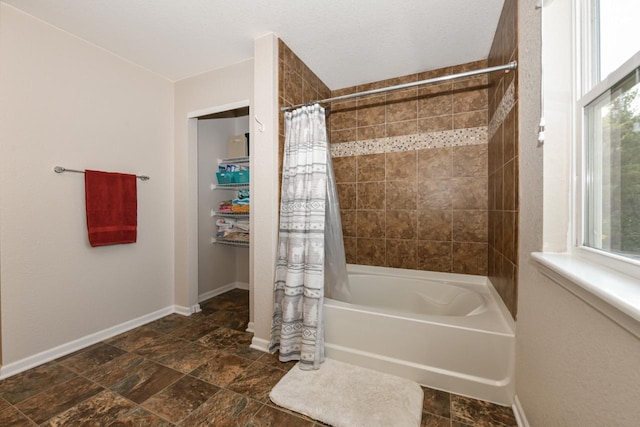 1557 Serena Ln, Burlington, WI 53105 - bathroom featuring shower / bath combination with curtain, healthy amount of natural light, and stone finish floors