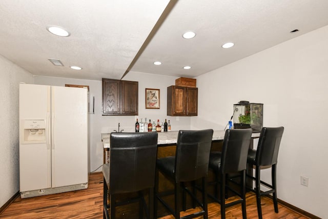 1557 Serena Ln, Burlington, WI 53105 - indoor wet bar with white refrigerator with ice dispenser, dark wood-style floors, and recessed lighting