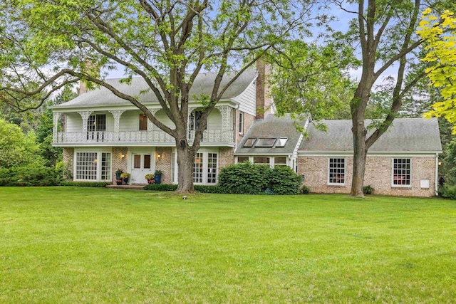544 Maple Bluff Rd, Stevens Point, WI 54482 - view of front of house with a chimney, a front yard, brick siding, and a balcony