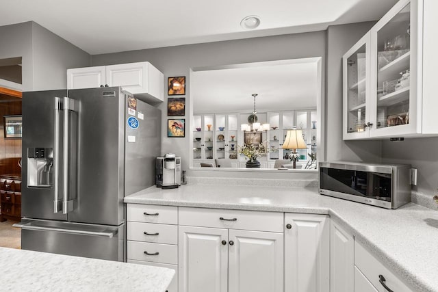 544 Maple Bluff Rd, Stevens Point, WI 54482 - kitchen featuring appliances with stainless steel finishes, glass insert cabinets, white cabinetry, light countertops, and a chandelier