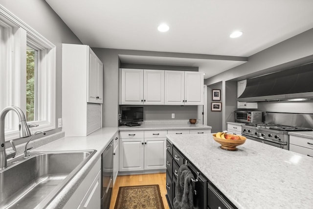 544 Maple Bluff Rd, Stevens Point, WI 54482 - kitchen with range, white cabinetry, wall chimney exhaust hood, light countertops, and recessed lighting