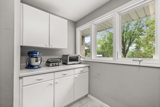 544 Maple Bluff Rd, Stevens Point, WI 54482 - kitchen with light countertops, white cabinetry, and light tile patterned floors