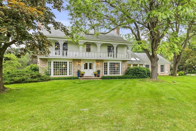544 Maple Bluff Rd, Stevens Point, WI 54482 - back of property featuring a chimney, a lawn, brick siding, and a balcony