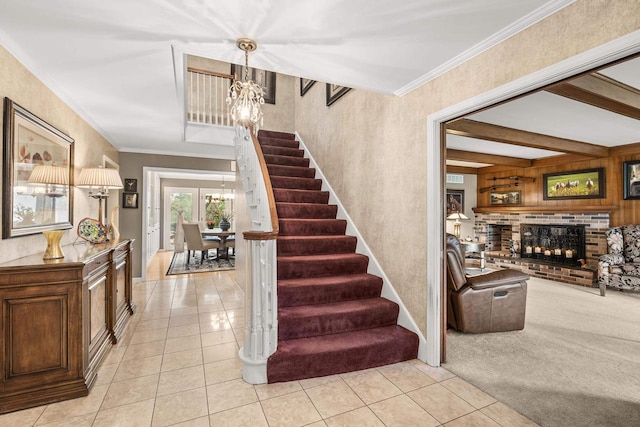 544 Maple Bluff Rd, Stevens Point, WI 54482 - staircase featuring a chandelier, tile patterned flooring, ornamental molding, and a fireplace